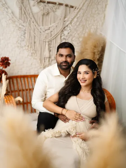 A beautiful, direct-to-camera portrait of the couple. Their happy expressions and the warm, earthy tones of the setup create a welcoming and joyful image.