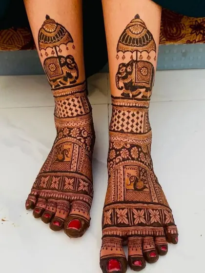 This royal foot design features decorated elephants under an umbrella on the ankles. It's a perfect match for a bride who has elephant motifs in her hand mehndi.