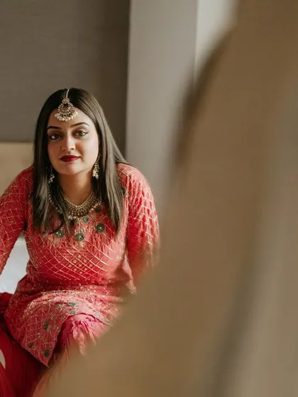 A candid moment of a sister looking at the bride, a quiet interaction full of love and admiration.
