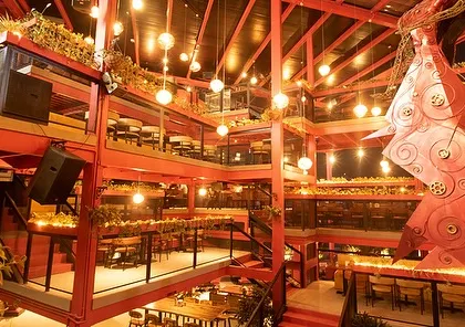 The multi-story atrium of Big Pitcher, where lighting and decorative elements are combined with greenery. The landscape design is integral to the venue's energetic and vibrant nightlife atmosphere.