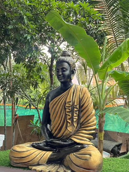 The serene presence of the Buddha sculpture amidst lush banana and palm leaves, showing how my art can complement and enhance natural surroundings.