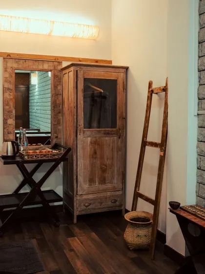 Rustic details like this wooden wardrobe and ladder basket add to the charm and functionality of our rooms.