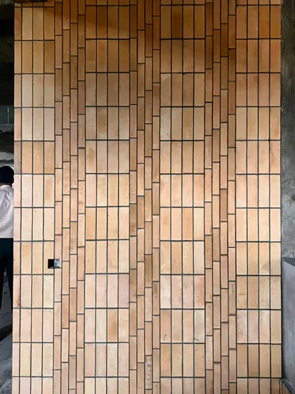 Experimenting with brickwork on-site to create a pixelated, textured facade. This hands-on process of laying out materials allows us to perfect the pattern and rhythm, ensuring the final wall is a work of true craftsmanship.