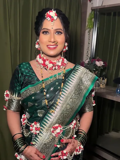 A beautiful look for a baby shower (dohale jevan). The mom-to-be is glowing in a traditional green saree, adorned with fresh floral jewellery.