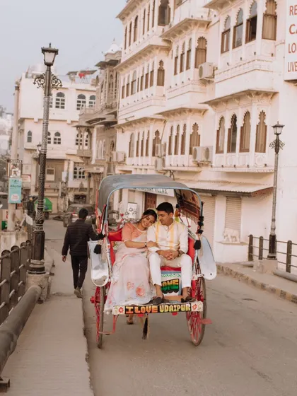 A charming shot of the couple enjoying a rickshaw ride through the historic streets of Udaipur, capturing the authentic and vibrant atmosphere of the city.