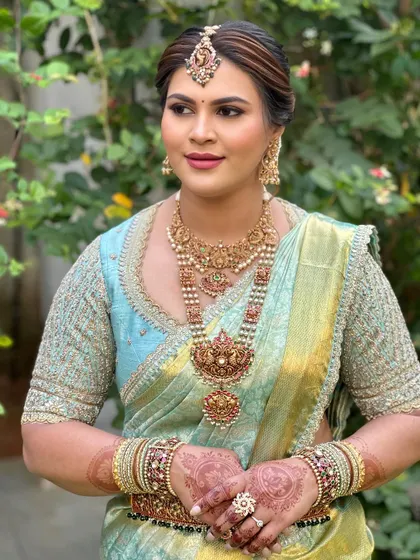 A side profile of Soumya's look, showing her glowing skin and traditional jewellery.