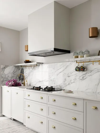 The beautiful kitchen from the Madras Home is luxe yet perfectly poised for everyday use. We used classic white shaker cabinets, a full-height marble backsplash, and brass hardware to create a timeless and elegant space.