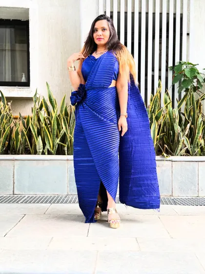 A full view of the royal blue pleated saree drape. The flower detail at the hip adds a unique, handcrafted touch.