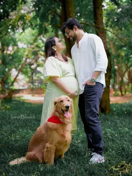 Sharing a loving gaze while their happy dog sits with them. This is a perfect example of a relaxed and joyful family maternity session in a Bangalore park.
