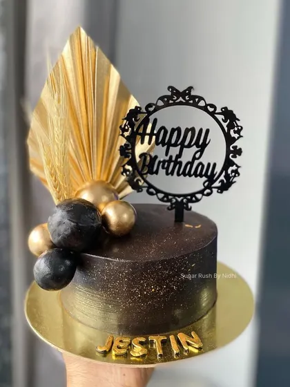 A bold and elegant black and gold cake. The contrast of the dark ganache with the shiny gold accents makes this a real showstopper for a man's birthday.