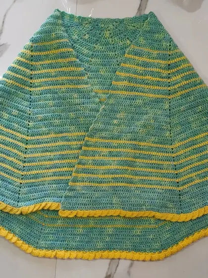 This image showcases the full spread of the lime green and yellow shawl. The bright yellow stripes and border create a wonderful contrast against the soft green.