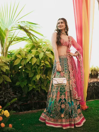 The bride poses with her stylish purse, showcasing her complete Sangeet look with confidence.