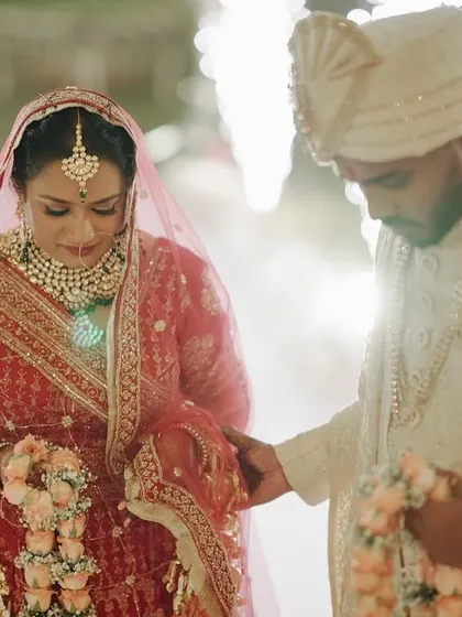 The couple exchanges garlands during their Varmala ceremony, surrounded by sparklers.