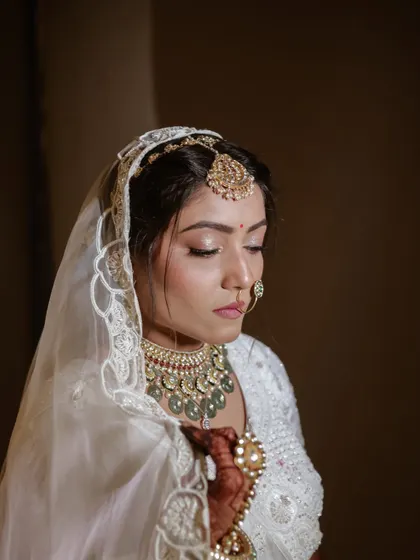 A classic, elegant bridal portrait. The soft lighting and the bride's calm expression make this a timeless photograph.