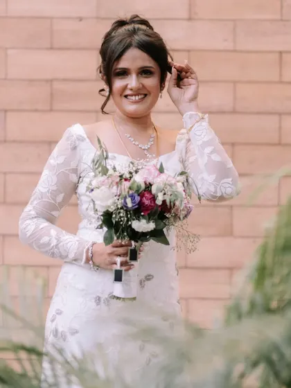 A lovely portrait of the bride. Her elegant updo and the delicate details of her gown are on full display.
