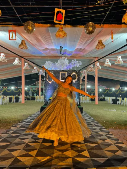 A joyful pose on the geometric-patterned dance floor of the Sangeet venue.