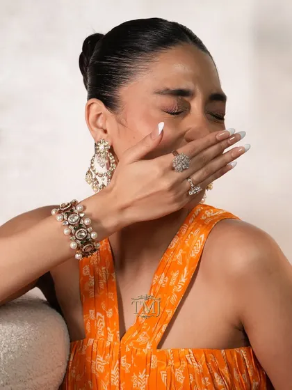 This stunning polki and pearl bracelet doubles up as a choker, shown here styled with matching pearl chandbalis and diamond rings for a complete, versatile look.