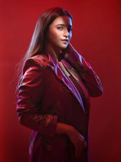 This wider shot shows more of the styling and posture, giving a fuller picture of the character and mood. The soft focus and red haze add a dreamy, atmospheric quality.