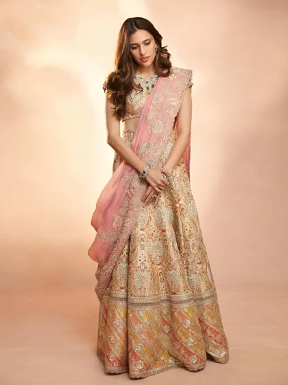 A soft and elegant look in this Anamika Khanna lehenga. The pastel tones and delicate embroidery are perfect for a daytime event, styled with beautiful emerald jewelry.