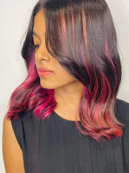 Another angle of the pink peekaboo highlights. This view shows how the brighter pink streaks are blended with softer tones for a multi-dimensional effect that is both fun and stylish.