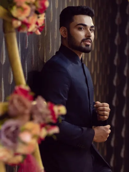 A happy client looking sharp in a classic navy blue bandhgala suit, perfect for a formal reception or engagement party.