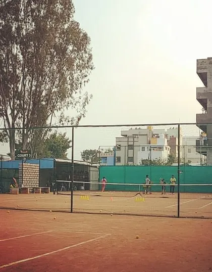 A view across multiple courts shows various training sessions happening simultaneously at the academy.