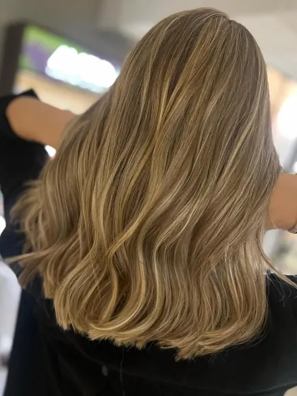 This beautiful caramel blonde look was achieved with back-to-back foils. This technique allows for a heavy concentration of highlights, resulting in a bright, blended blonde.