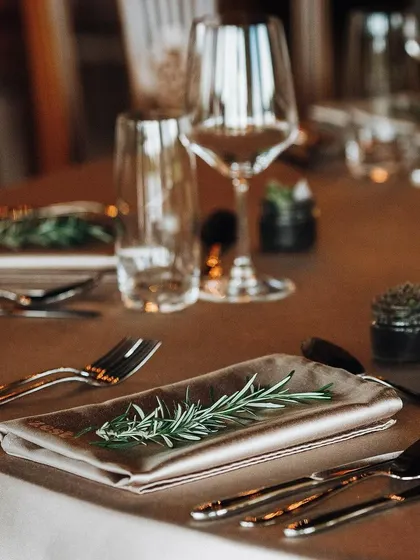 An elegant table setting with a rosemary sprig on the napkin, showing our attention to detail.