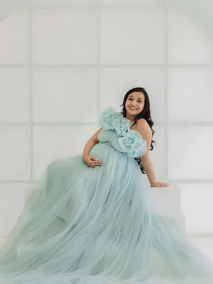 A happy and glowing mom-to-be. This shot showcases how the ice blue gown drapes beautifully even when seated, making it comfortable and gorgeous for a variety of poses.