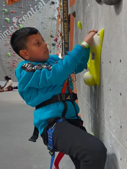This young climber is focused and determined as he reaches for a hold. We foster an environment where kids can challenge themselves and celebrate their achievements.