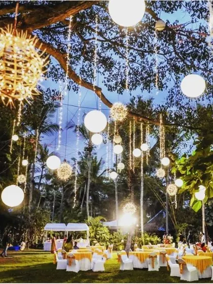 An evening reception on our lawn, with tables set under a sky of hanging lanterns and fairy lights, creating memories that last forever.
