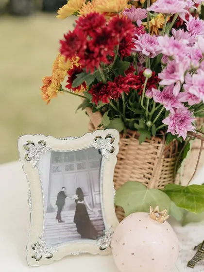 A close-up of a framed photo and a floral arrangement.