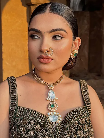 A profile view of the modern look, showcasing the clean lines of the makeup and the sleek, polished hairstyle.