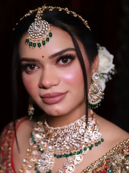 Another angle of the elegant royal bride, showing off the beautiful floral bun and the delicate 'sheesh patti'.