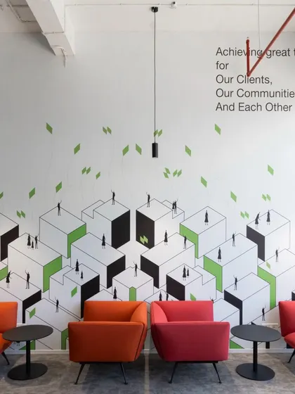 This graphic wall visualizes the company's values of community and achievement through an isometric cityscape. Our holistic design approach often includes creating these custom environmental graphics to reinforce an organization's culture and mission directly within the built environment.