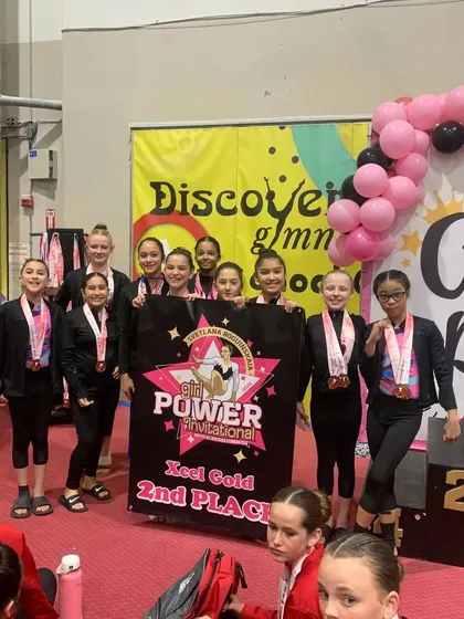 Our Xcel Gold team with their 2nd place banner. A fantastic achievement for these hardworking athletes.