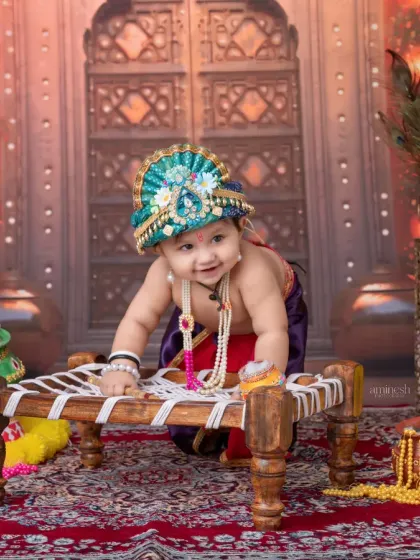 This playful pose on a traditional charpai captures the mischievous nature of little Krishna. The backdrop, with its warm lights and peacock motifs, adds to the divine theme.