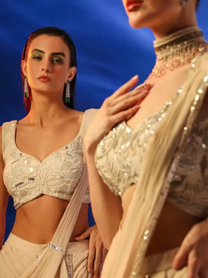 A dual-model shot featuring two different embellished blouses in a neutral palette. The composition creates a beautiful contrast and highlights the intricate details of each piece.
