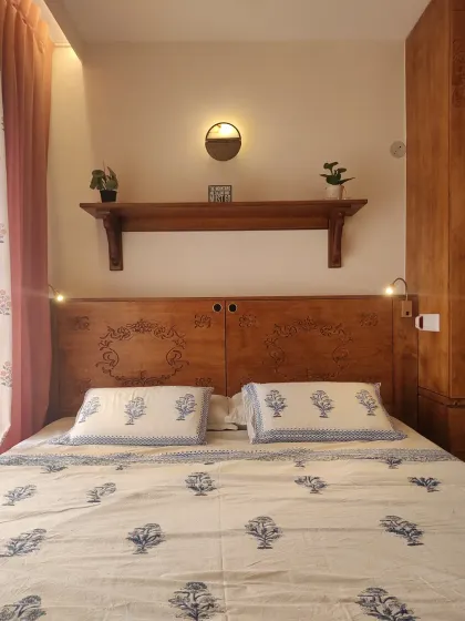 The king-size platform bed dressed in simple, elegant linens. The integrated reading lights are a practical addition for nighttime reading.