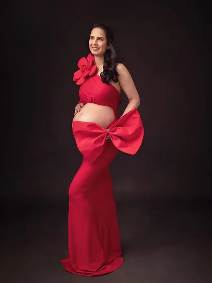 A fun and fashionable statement with a large red bow. Props and accessories can add a playful and unique element to your maternity portraits.
