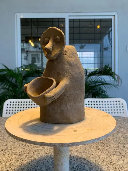 Another angle of the expressive, hand-built sculpture. The simple form and posture convey a deep sense of emotion.