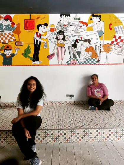 A final shot with my teammate, proud of the vibrant story we painted onto this wall.