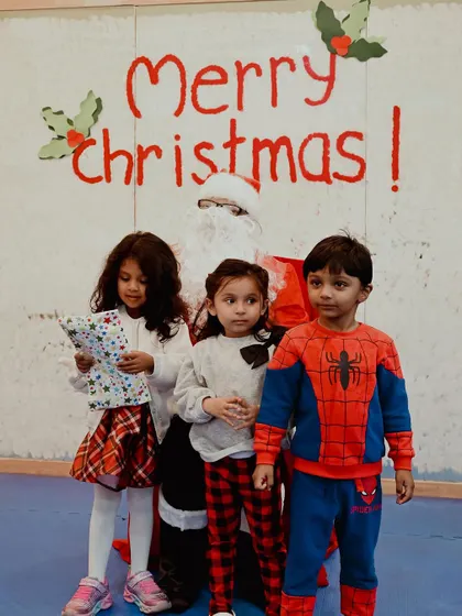Three children gather around Santa for a memorable photo.
