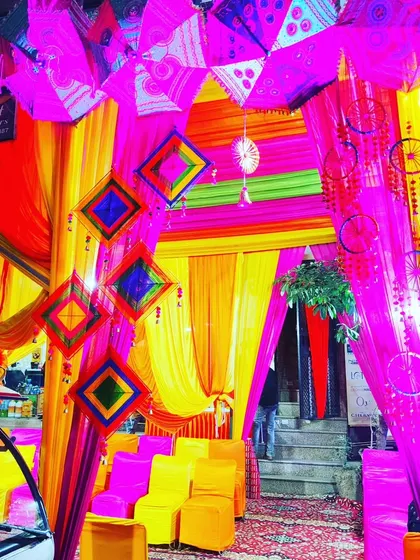A close-up of the tent's entrance decor, featuring hanging dreamcatchers, umbrellas, and layered drapes.