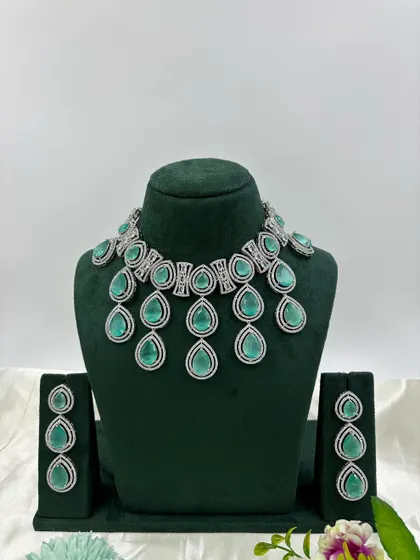 A modern necklace set with large, teardrop-shaped stones in a cascading design. This piece is available in several colors, including pink, green, and red, offering a bold and stylish look.