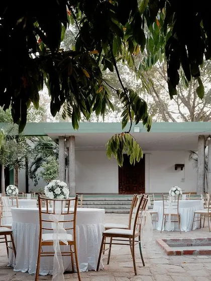 Outdoor seating arrangements for the Sangeet, with simple floral centerpieces.