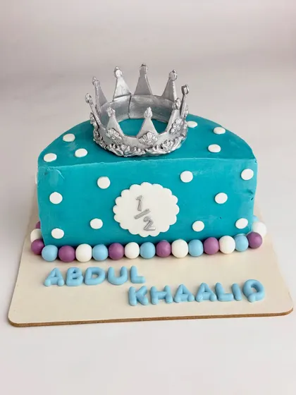 A full frontal view of the half-birthday cake, showing the name "Abdul Khaaliq" in fondant letters.
