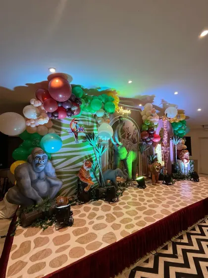 A side view of the grand jungle stage, showing the vibrant green and brown color palette and the variety of animal props used.