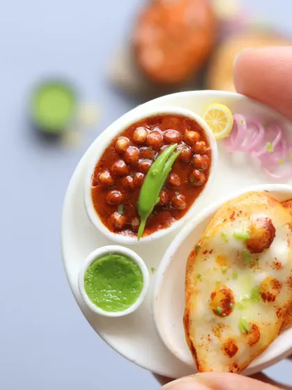 A close-up of a naan and channa masala miniature, showing the texture of the bread and the rich gravy.