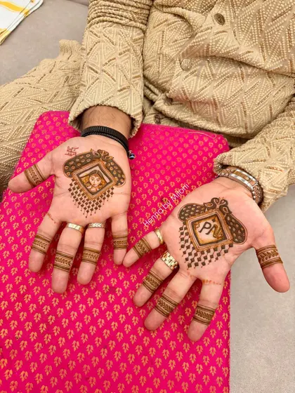 Mehendi for the groom. This design features the couple's initials and a small portrait of the bride, a sweet gesture for his wedding day.